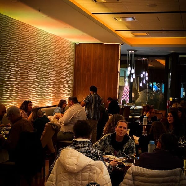 Diners enjoying a meal in the warm, inviting atmosphere of Aman's Artisan Indian Cuisine restaurant.